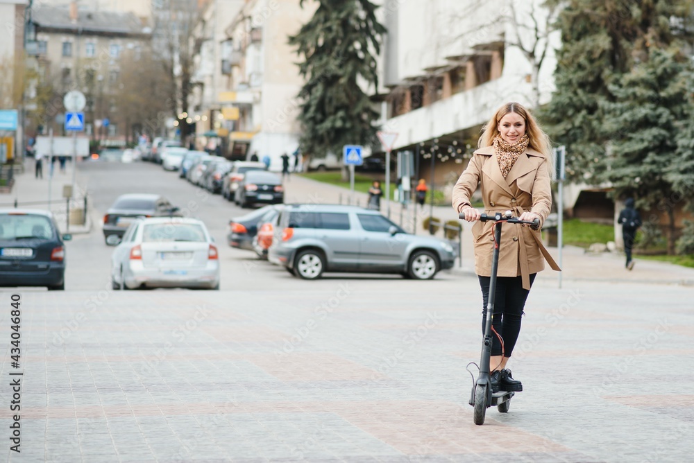 Young woman on electro scooter in city.