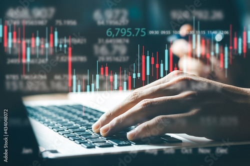 Businessman working in office, technical price chart and red and green candlestick chart indicator and computer screen background for stock trading, double exposure Traders analyze data.