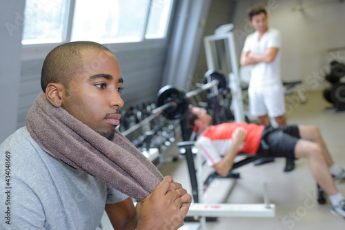 Pensive man resting in exercise gym