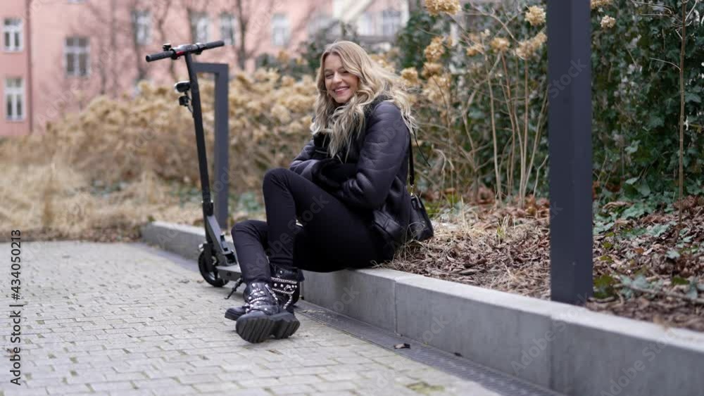Happy female with electric scooter resting in autumn park Happy female with electric scooter resting in autumn park