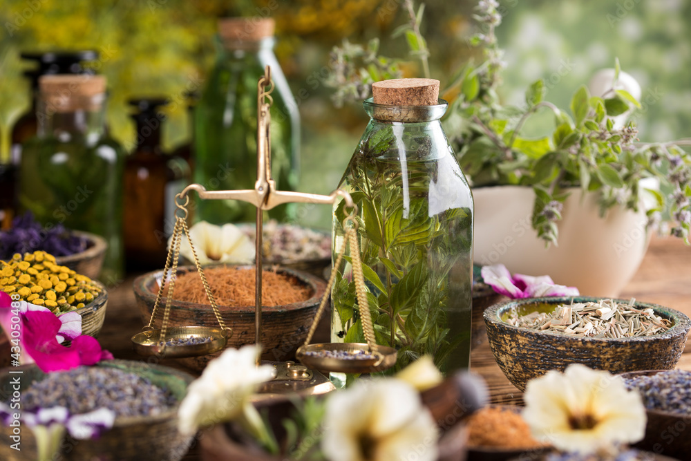 Fresh herbs and oil, wooden table background