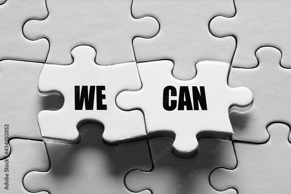 Fototapeta premium Jigsaw puzzle piece with the message we can. Togetherness, teamwork, solidarity, success and achievement