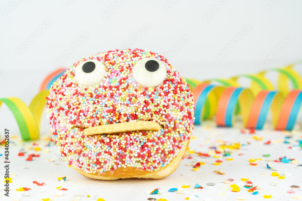 Funny face cake with confetti and streamers, white background Funny face cake with confetti and streamers, white background