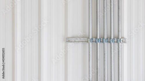 Background of structural and architectural interior white wall in house or building with aluminium grey drainpipes or water spout and blank copy space.