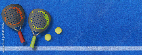 Close up of a padel ball and rackets on a blue syntehtic playground	 photo