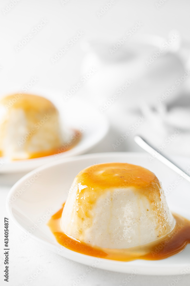 Panna cotta with pears - italian dessert of sweetened cream thickened with gelatin, with caramel sauce. High-key light. Vertical image. Panna cotta with pears - italian dessert of sweetened cream thickened with gelatin, with caramel sauce. High-key light. Vertical image.