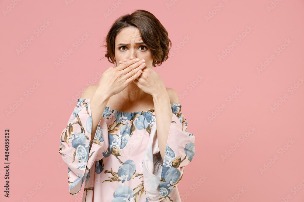 Young shocked amazed impressed astonished confused woman 20s with short hairdo wearing trendy blouse covering mouth with hands arms isolated on pastel pink background studio People lifestyle concept. Young shocked amazed impressed astonished confused woman 20s with short hairdo wearing trendy blouse covering mouth with hands arms isolated on pastel pink background studio People lifestyle concept.