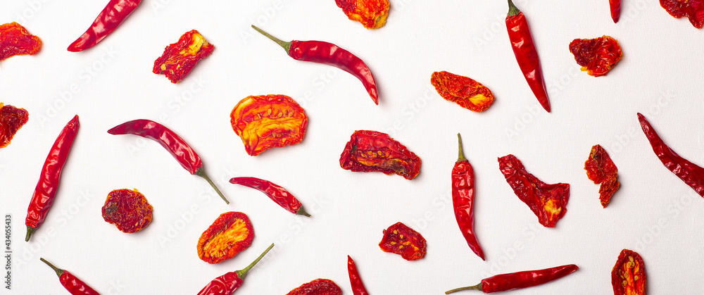 Peppers and tomatoes banner background. Dried hot chili peppers and red sun-dried tomatoes on a white plate. Spices and vegetables food minimal flat lay background concept - obrazy, fototapety, plakaty 