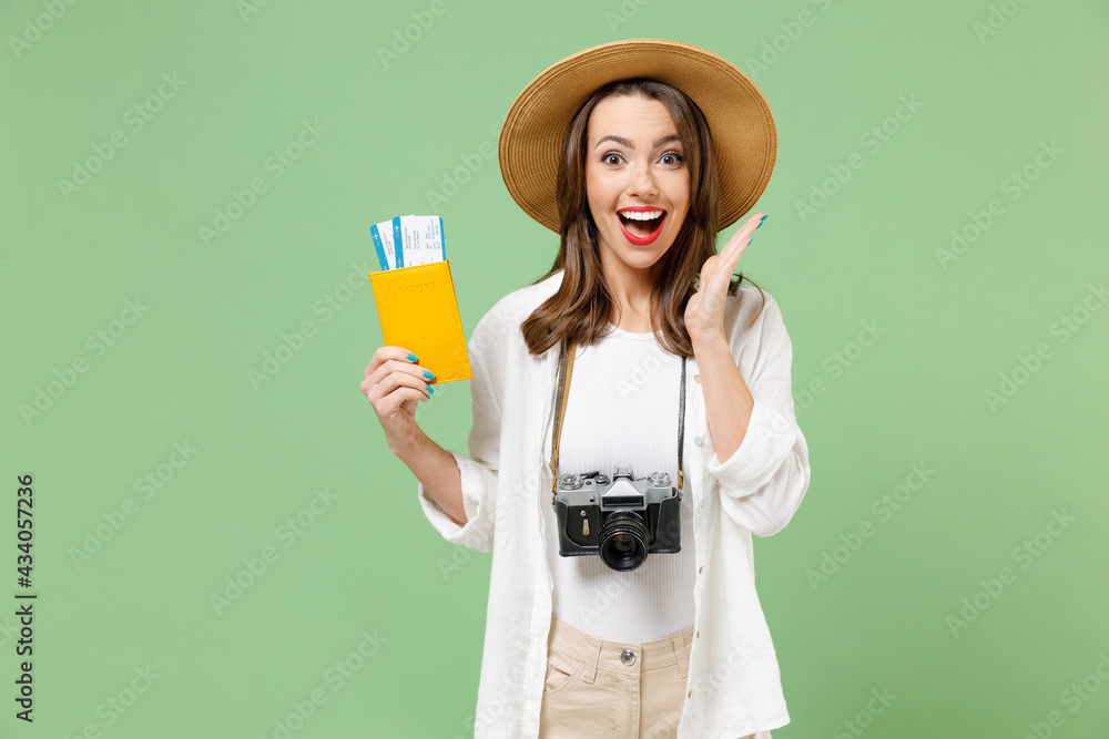 Traveler fun excited happy tourist woman in casual clothes hat camera passport tickets hold face isolated on green background Passenger travel abroad on weekends getaway. Air flight journey concept. Traveler fun excited happy tourist woman in casual clothes hat camera passport tickets hold face isolated on green background Passenger travel abroad on weekends getaway. Air flight journey concept.