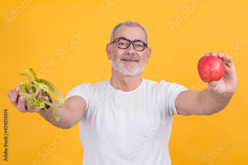 man with apple and with a measuring tape in hand, concept of diet and health photo