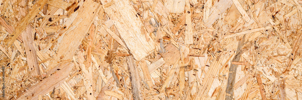 abstract textured background of compressed plywood. texture of light brown pressed wooden board chipboard. top view, close up. banner