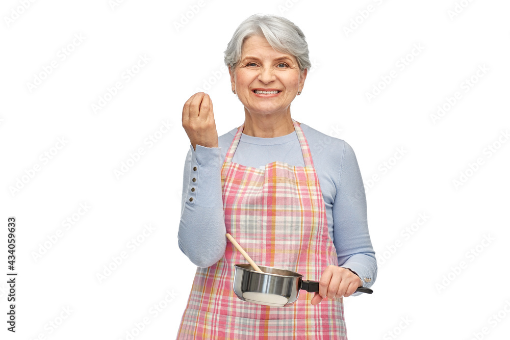 food cooking, culinary and old people concept - portrait of smiling senior woman in kitchen apron with pot and spoon over white background food cooking, culinary and old people concept - portrait of smiling senior woman in kitchen apron with pot and spoon over white background