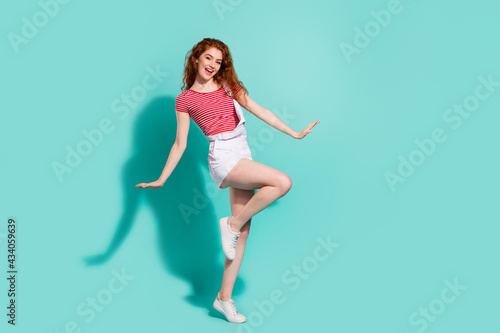 Full length body size view of nice pretty cheerful girl dancing posing having fun isolated bright blue color background