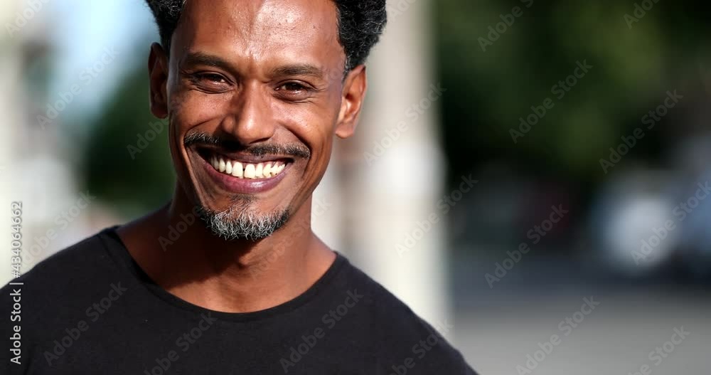 Fun black African man laughing and smiling standing outside Fun black African man laughing and smiling standing outside