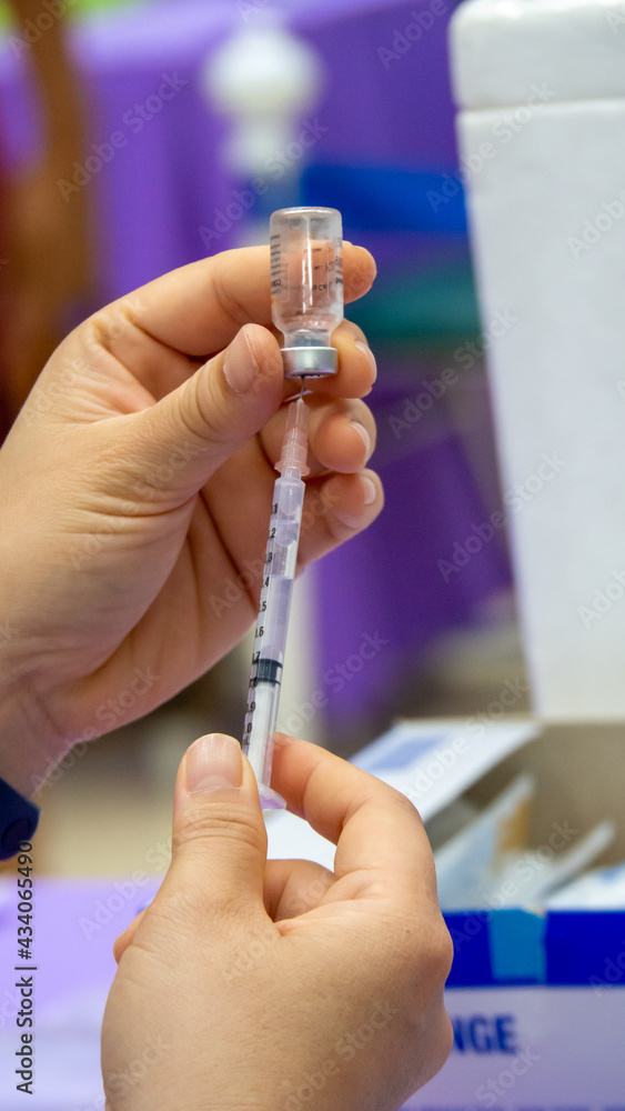 Getting the COVID 19 vaccine out of the vial using a syringe. Getting the COVID 19 vaccine out of the vial using a syringe.