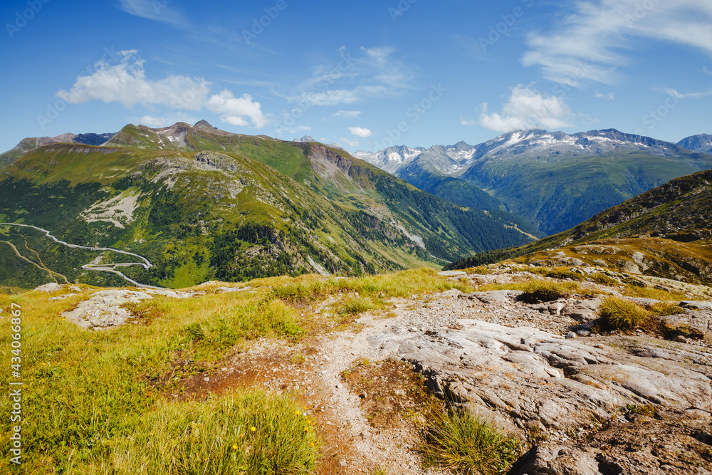 Panorama of mountain slopes in the sunny day. Location place of Grimselpass in the canton of Valais, Swiss alps, Europe.