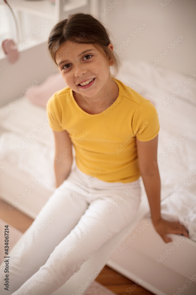 Smiling little girl playing in bedroom alone. Smiling little girl playing in bedroom alone.