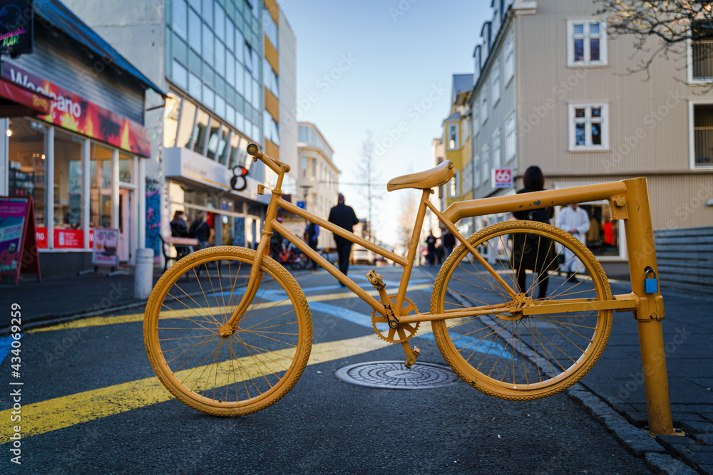 The vibrant yellow bicycle  mark the beginning of a cycling path in the busy city center of the Reykjavik, Iceland 