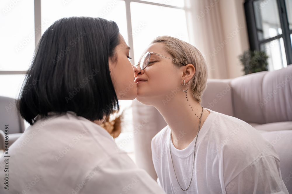 young lesbian couple kissing at home