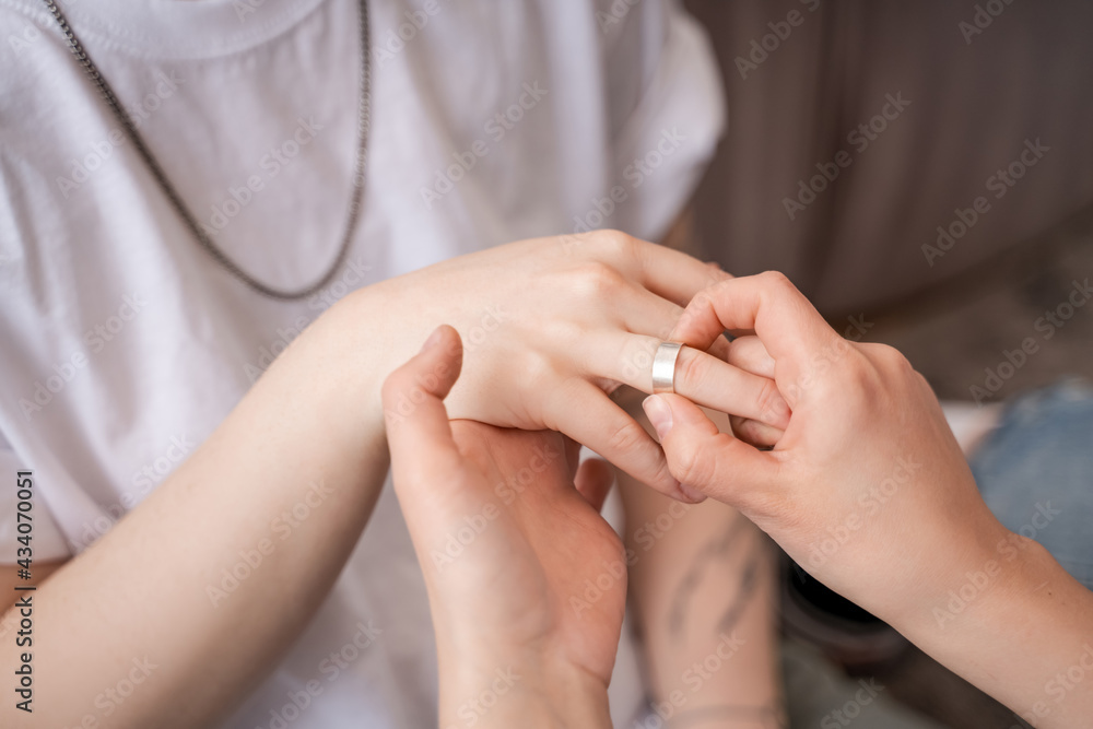cropped view of woman wearing ring on finger of girlfriend cropped view of woman wearing ring on finger of girlfriend