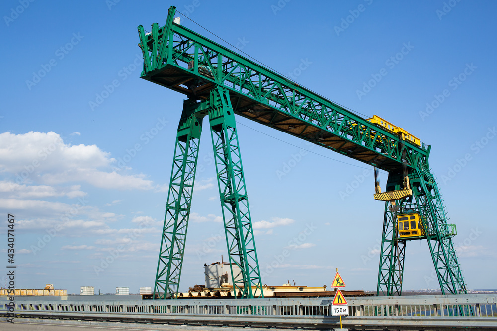 Green gantry crane near the road bridge.