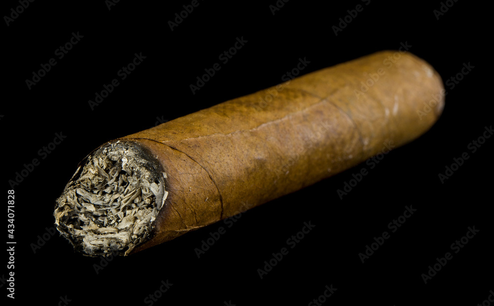 Cigar isolated on a black background close-up.