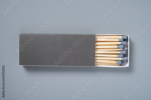 grey color matchbox and grey match sticks on a grey background