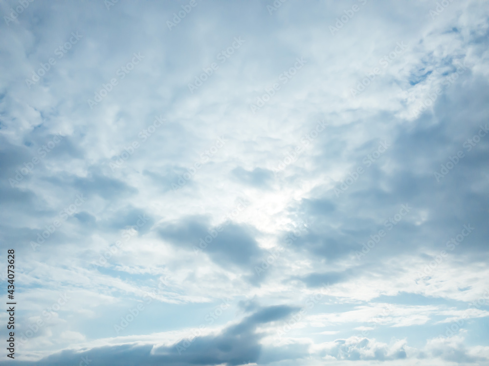 In the blue sky, clouds obscure the sun.