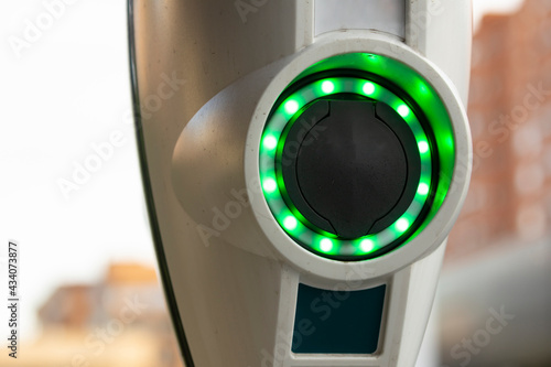 A battery charging point for electric cars, illuminated with green LEDs, in the area of the Retiro district, in Madrid, Spain.