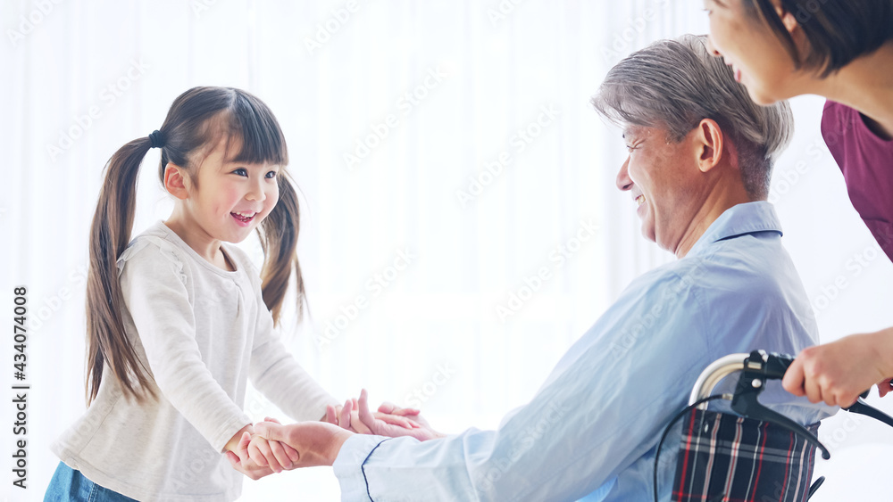 Obraz premium 車椅子のシニア男性とエッセンシャルワーカー お見舞いに来た女の子 介護イメージ