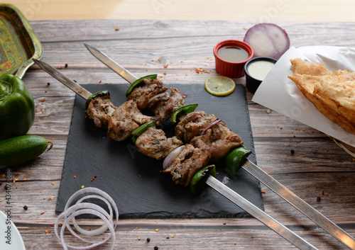 Adana Kebab, Turkish Kabab & Lebanoni Boti  served in a wooden cutting board isolated on wooden background side view
 photo