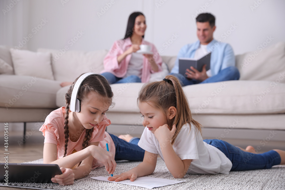 Family in living room with comfortable sofa, focus on children Family in living room with comfortable sofa, focus on children