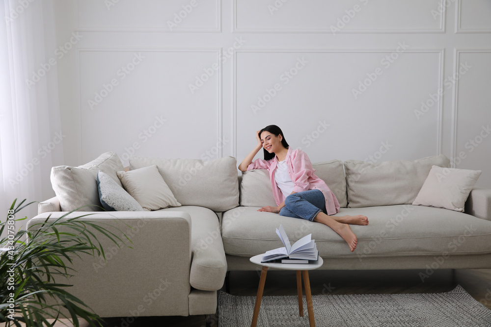 Woman resting on sofa in living room Woman resting on sofa in living room