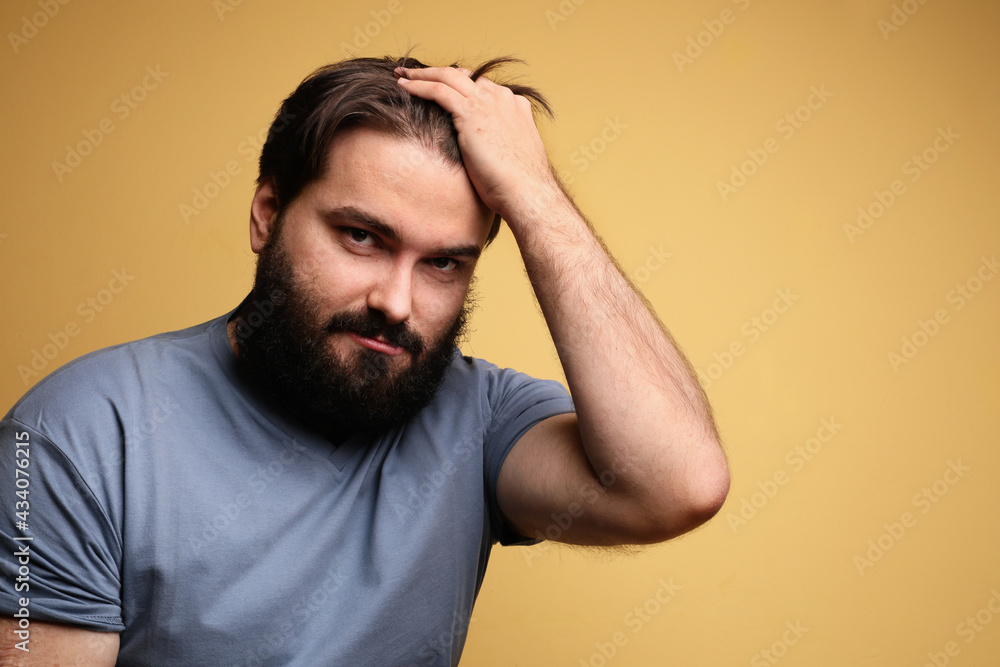 Portrait of big man with beard, posing over yellow background. Isolated. Portrait of big man with beard, posing over yellow background. Isolated.