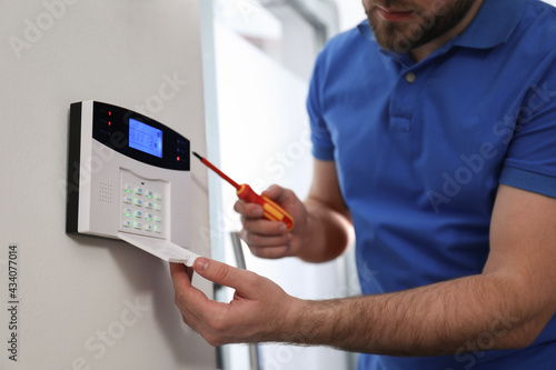 Obraz na płótnie Man installing home security system on white wall in room, closeup