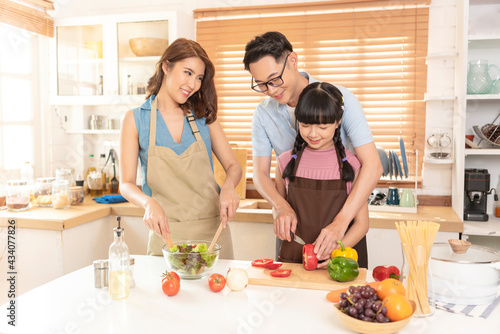 Asian family enjoy cooking salad together in kitchen room at home.