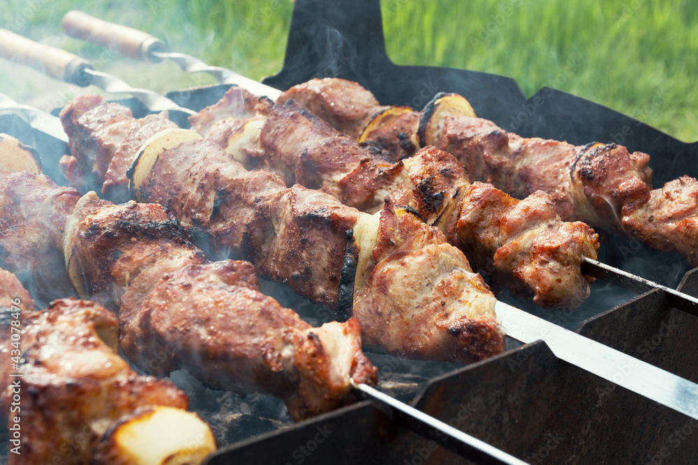 Marinated shashlik preparing on a barbecue grill over charcoal. Shashlik or Shish kebab popular in Eastern Europe. Shashlyk (skewered meat) was originally made of lamb. Roast Beef Kebabs On BBQ Grill.