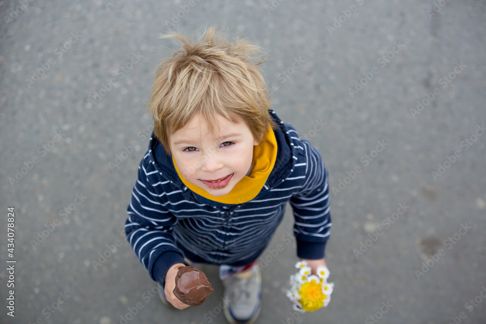Fototapeta premium Cute blond child, boy, eating ice cream in the park
