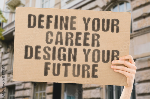 The phrase " Define your career. Design your future " on a banner in men's hand with blurred background. Education. Success. Study. College. University. Knowledge © AndriiKoval