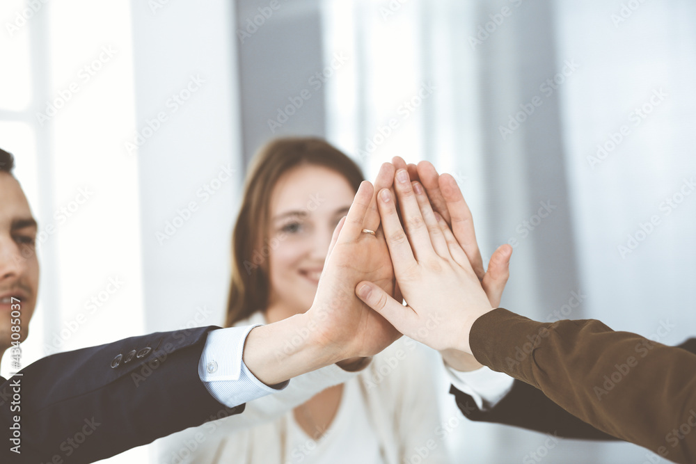 Business people group showing teamwork and joining hands or giving five in modern office. Unknown businessman and women making circle with their hands Business people group showing teamwork and joining hands or giving five in modern office. Unknown businessman and women making circle with their hands