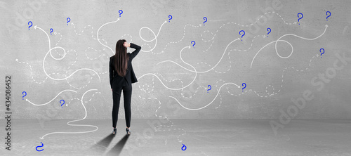 Photos Answer for the questions concept with businesswoman in front of concrete wall with white curved lines and question marks