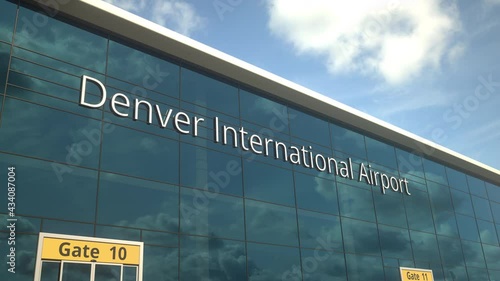 Landing airplane reflects in the modern windows with Denver International Airport text photo