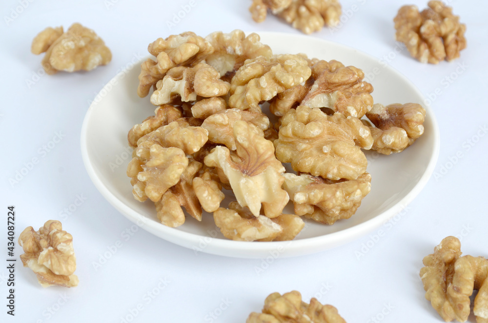 walnuts on a white plate, white background walnuts on a white plate, white background