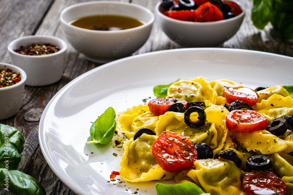 Tortelloni stuffed with prosciutto ham and vegetables on wooden table Tortelloni stuffed with prosciutto ham and vegetables on wooden table