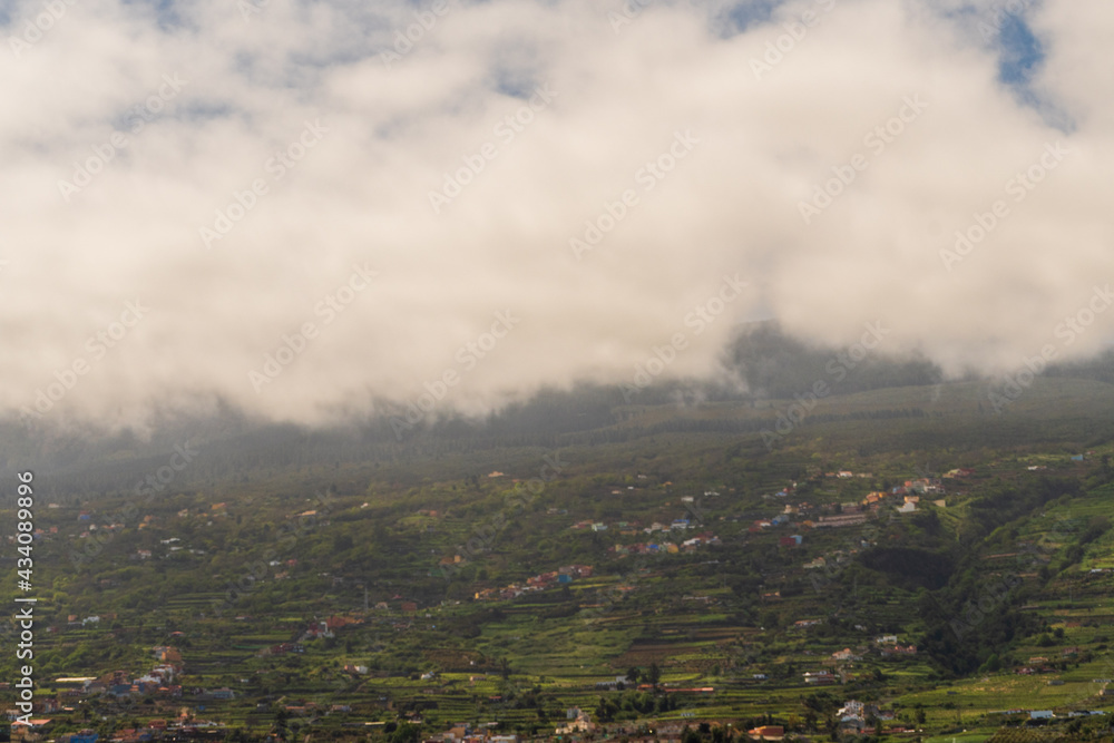 Montaña con vegetación tapada de manera parcial por las nubes