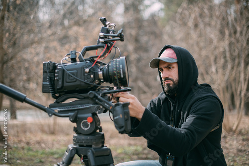 Director of photography with a camera in his hands on the set. Professional videographer at work on filming a movie