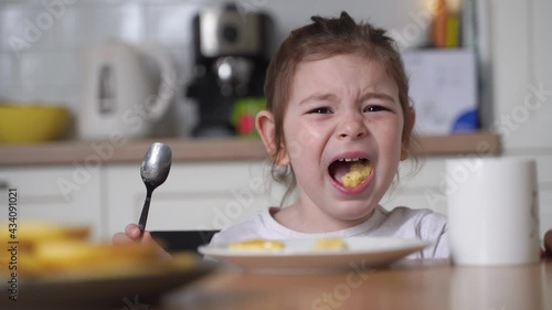 Toddler girl screaming at dinner table. Bad manner, restaurant tantrum. Throwing food, angry child. Bad etiquette 