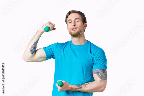 sporty man with pumped up arms dumbbells workout tattoo cropped view