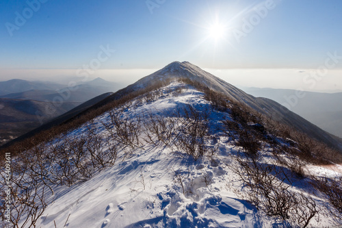 The snowy peaks of the Sestra mountain in the Lazovsky district of the Primorsky Territory. Rocky ridge of a high mountain. Mountain landscape. photo