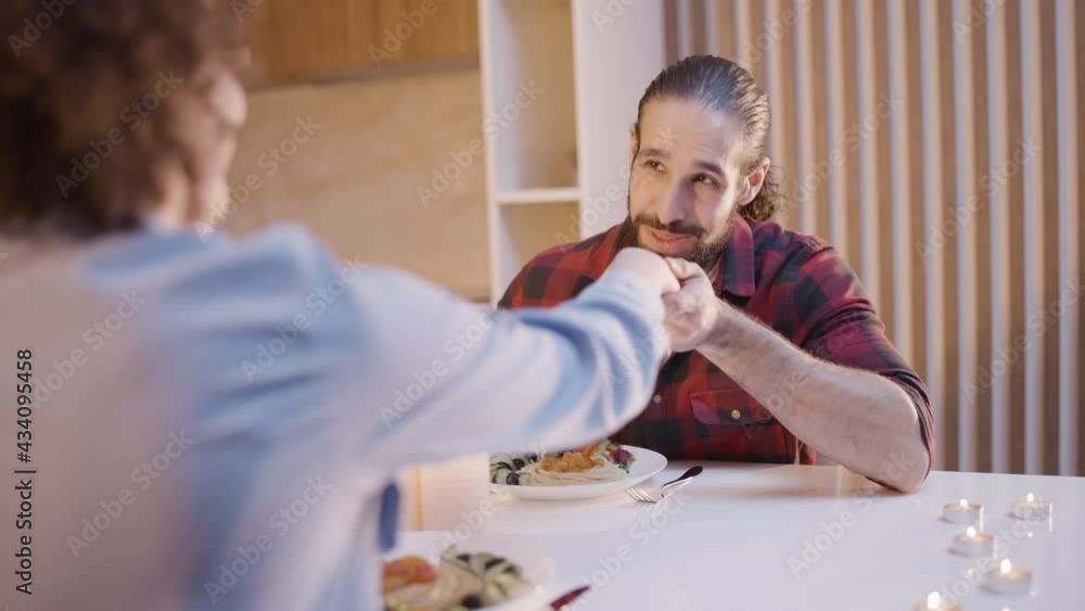 Smiling middle eastern man kissing woman's hand, romantic relationship, love